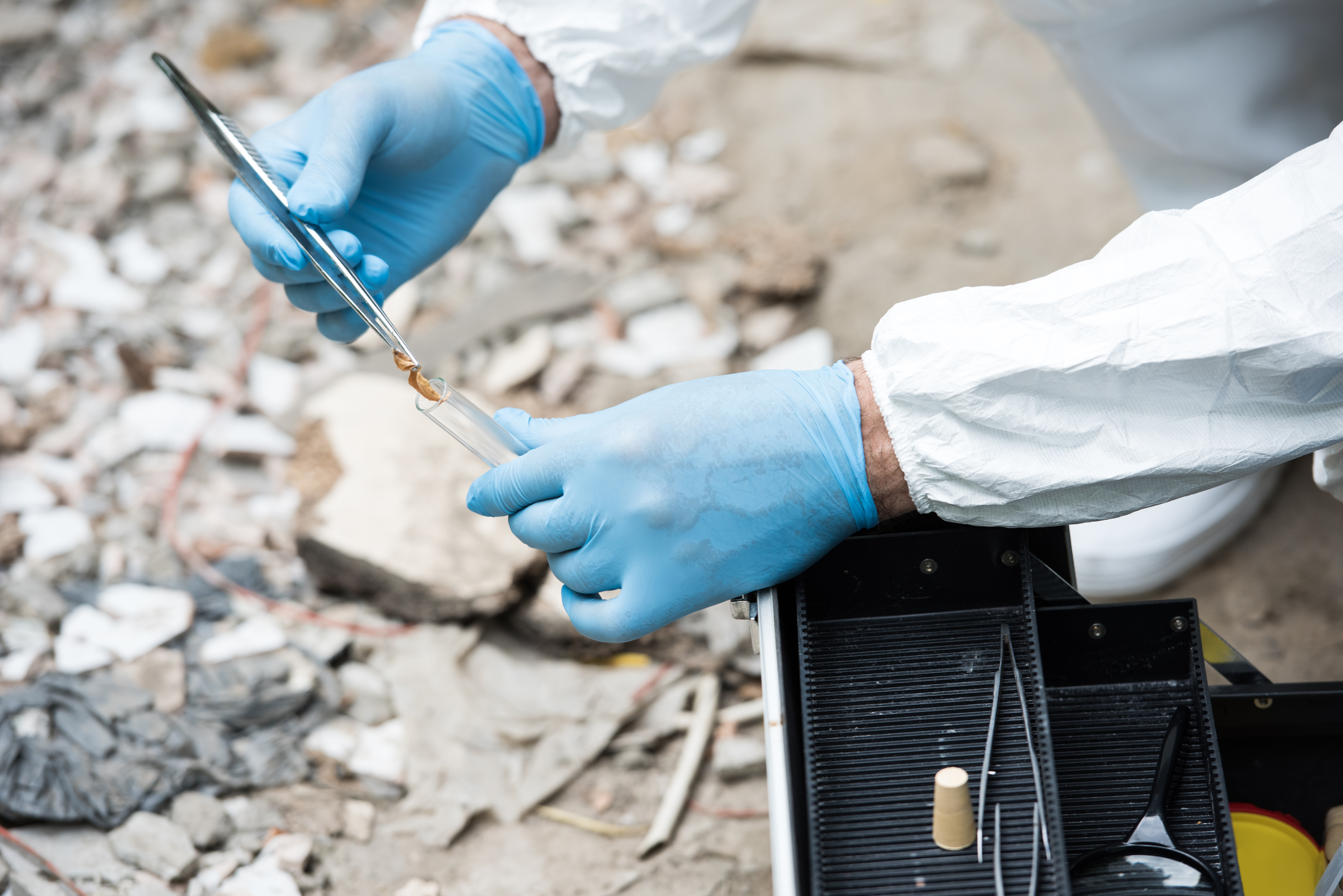 Technician placing a soil sample into a test tube on site